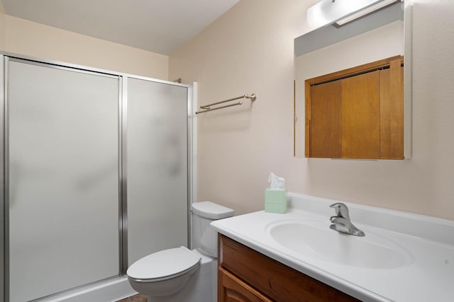 full bathroom with vanity, a shower stall, and toilet