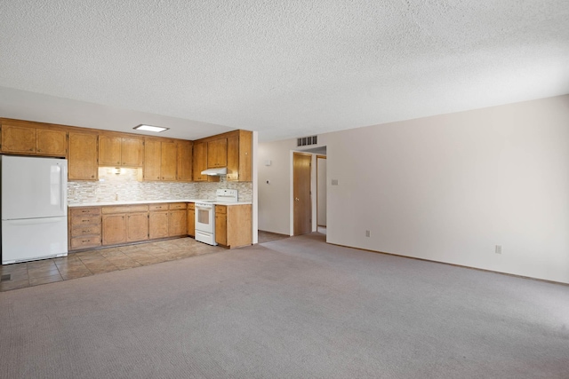 kitchen featuring white appliances, visible vents, light countertops, under cabinet range hood, and light carpet