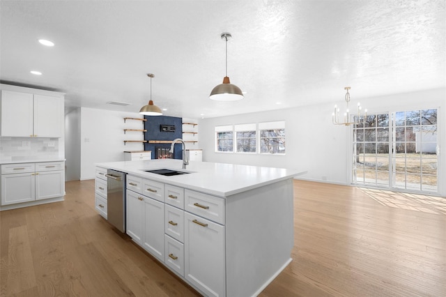 kitchen with light wood-style flooring, white cabinets, backsplash, and a sink