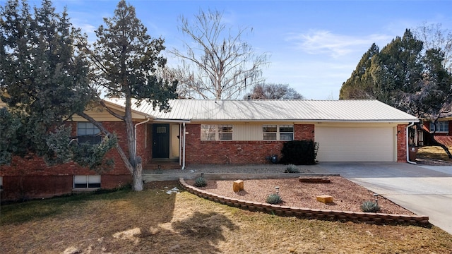 ranch-style home with concrete driveway, an attached garage, brick siding, and metal roof