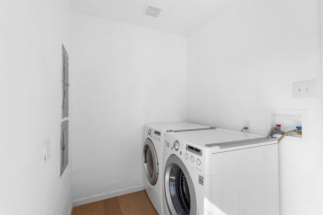 laundry room featuring visible vents, washer and dryer, light wood finished floors, baseboards, and laundry area