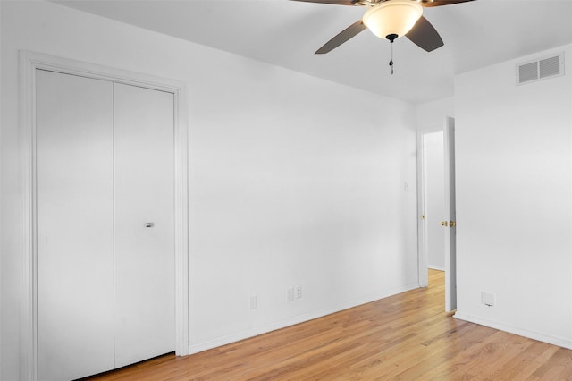 unfurnished bedroom with light wood finished floors, visible vents, a ceiling fan, and baseboards