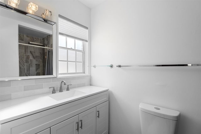 full bathroom featuring decorative backsplash, toilet, vanity, and a tile shower