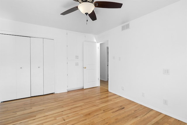 unfurnished bedroom featuring visible vents, light wood-style flooring, a ceiling fan, a closet, and baseboards