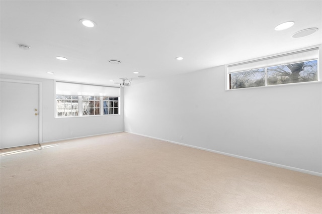 spare room featuring recessed lighting, plenty of natural light, and light carpet