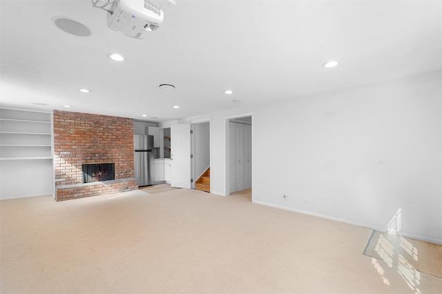 unfurnished living room featuring baseboards, recessed lighting, stairs, light carpet, and a brick fireplace