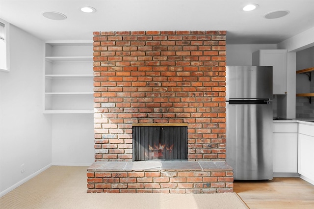 room details featuring recessed lighting, baseboards, a brick fireplace, and freestanding refrigerator