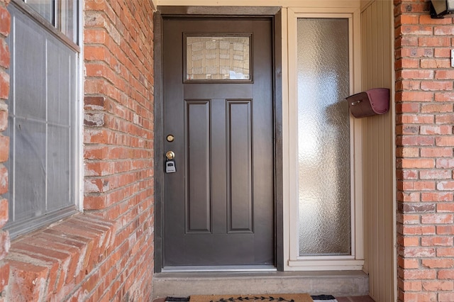 entrance to property featuring brick siding