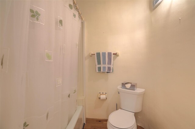 full bathroom featuring toilet and wood finished floors