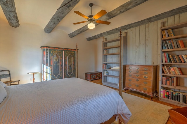 bedroom featuring beam ceiling and wood finished floors