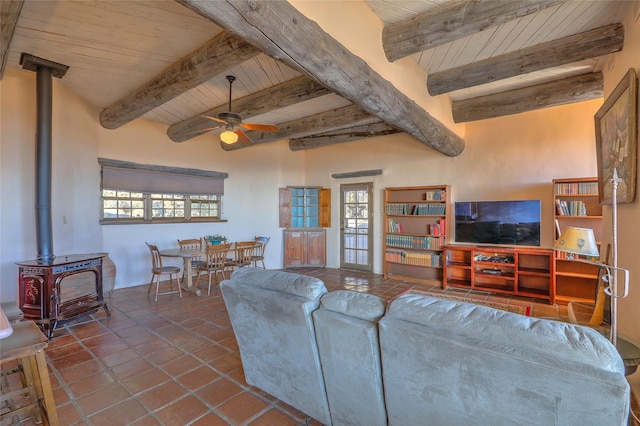 tiled living room with a wood stove, wood ceiling, beamed ceiling, and ceiling fan