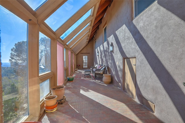 sunroom / solarium featuring lofted ceiling with skylight