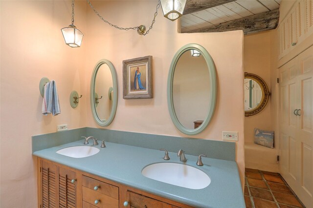 full bathroom featuring double vanity, beam ceiling, wood ceiling, and a sink