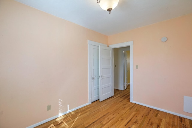 empty room with light wood-style flooring and baseboards