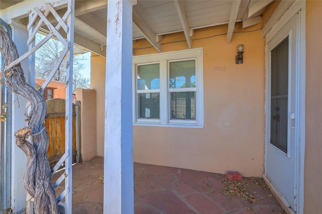 doorway to property featuring stucco siding