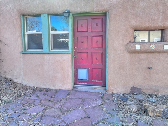 entrance to property featuring stucco siding