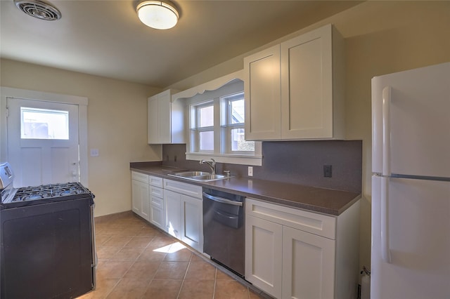 kitchen with visible vents, a sink, dark countertops, stainless steel appliances, and white cabinets