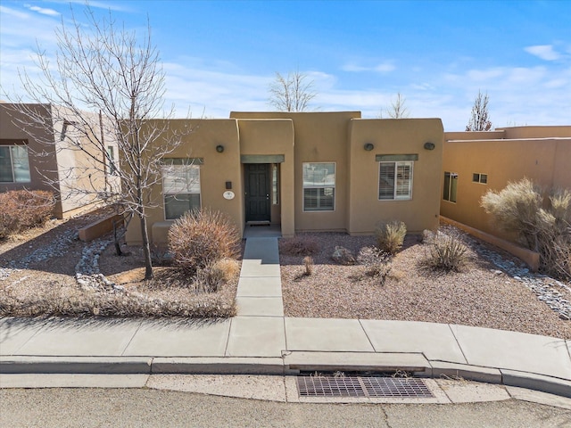 pueblo-style house featuring stucco siding