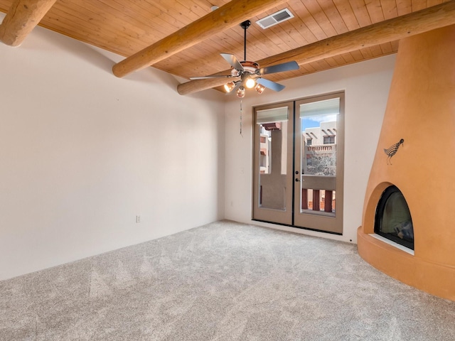 unfurnished living room featuring visible vents, beam ceiling, a ceiling fan, carpet floors, and wooden ceiling