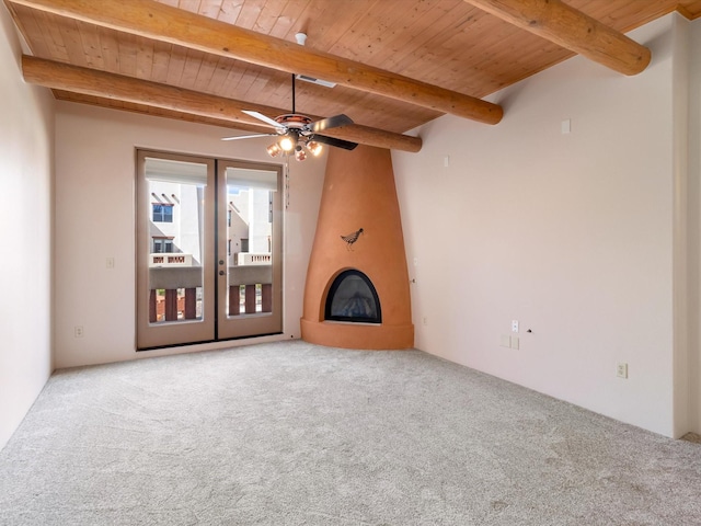 unfurnished living room featuring wood ceiling, carpet flooring, beamed ceiling, a ceiling fan, and a fireplace