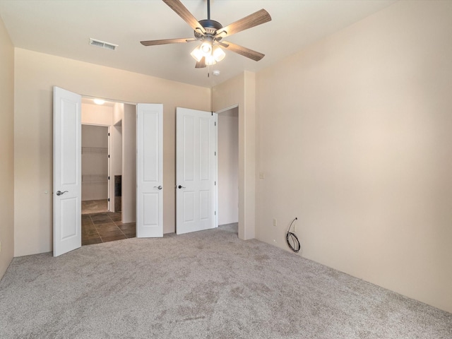 unfurnished bedroom featuring carpet flooring, visible vents, and ceiling fan