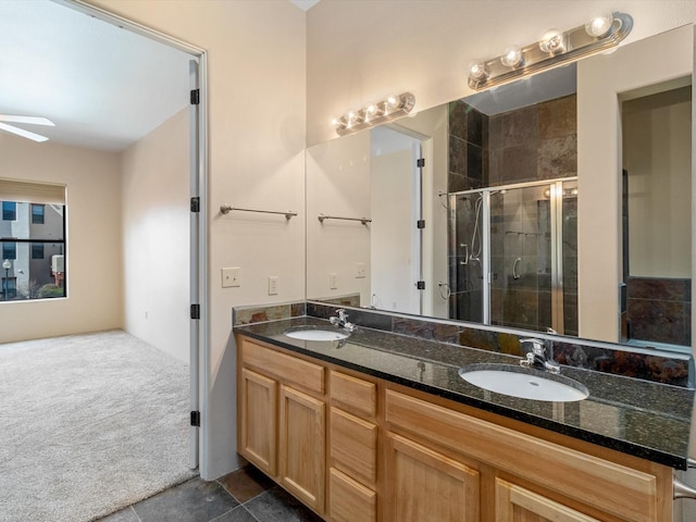 full bath featuring double vanity, a stall shower, ceiling fan, and a sink