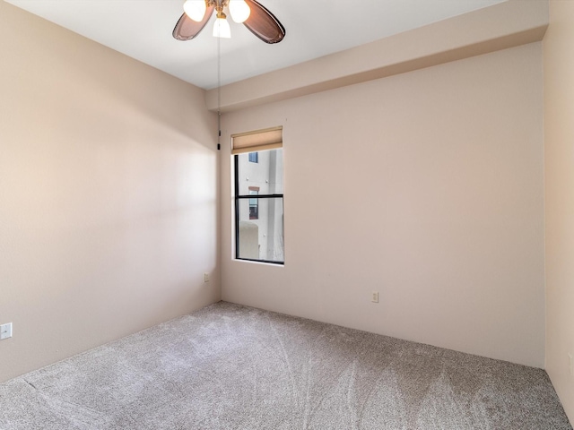 carpeted spare room with a ceiling fan