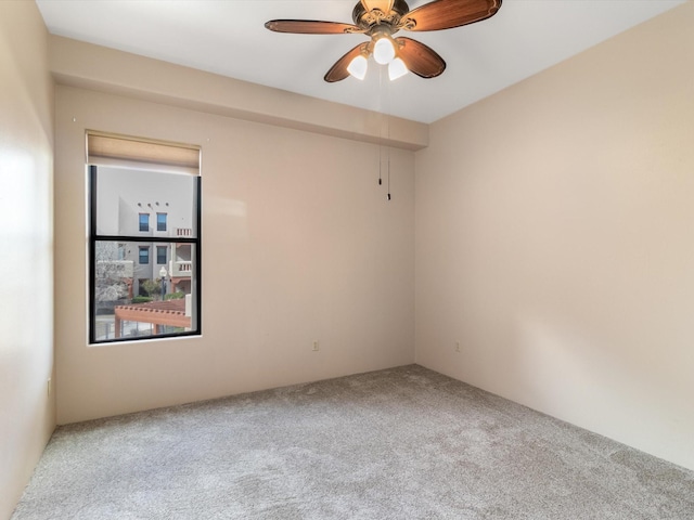 carpeted spare room featuring a ceiling fan