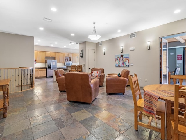 living area featuring recessed lighting, visible vents, and stone tile flooring