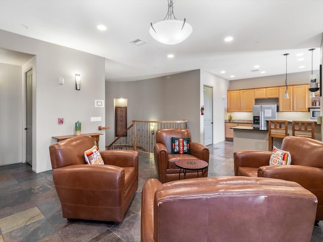 living area with visible vents, recessed lighting, and stone finish flooring