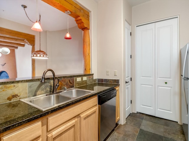 kitchen featuring stone finish flooring, pendant lighting, dark stone countertops, appliances with stainless steel finishes, and a sink