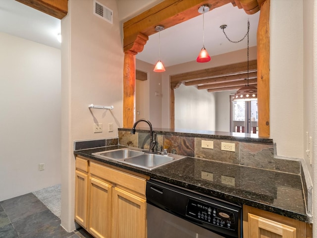 kitchen featuring stainless steel dishwasher, a sink, hanging light fixtures, and dark stone counters