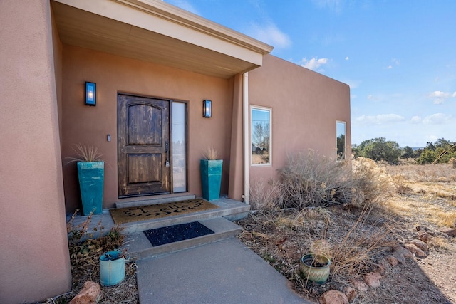 view of exterior entry with stucco siding