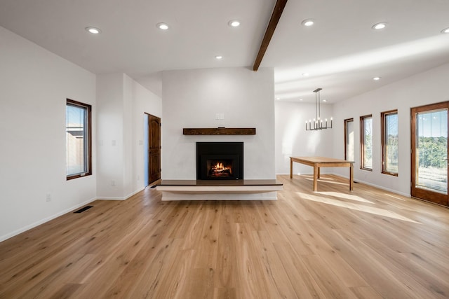 unfurnished living room featuring recessed lighting, light wood-type flooring, a warm lit fireplace, and visible vents