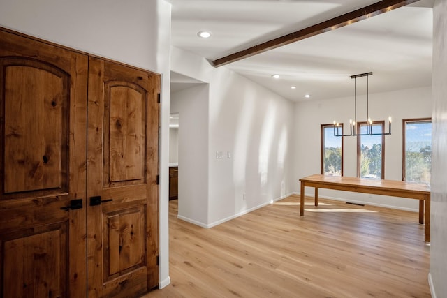 interior space featuring beam ceiling, a notable chandelier, recessed lighting, light wood finished floors, and baseboards