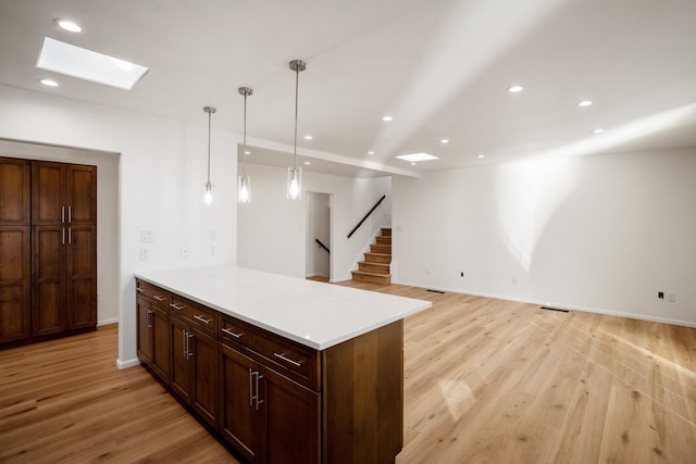 kitchen featuring recessed lighting, light wood-type flooring, a skylight, and light countertops