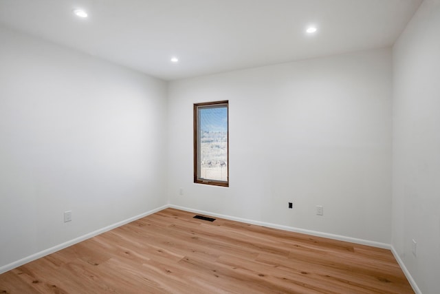 spare room featuring light wood finished floors, visible vents, recessed lighting, and baseboards