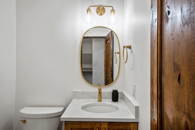 half bathroom with vanity and toilet