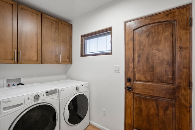 clothes washing area featuring cabinet space, independent washer and dryer, and baseboards