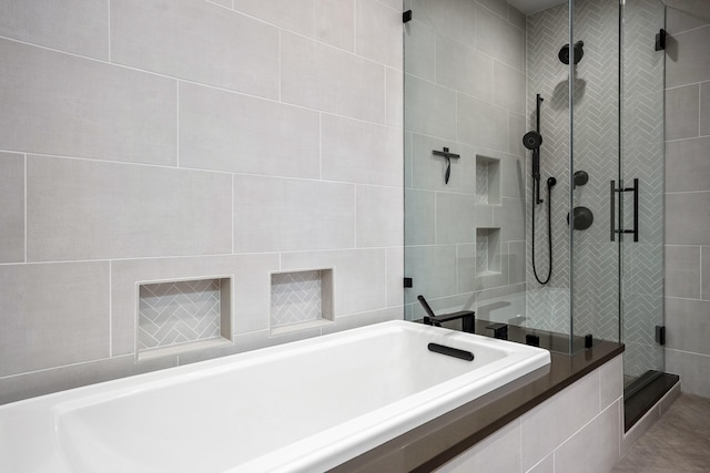 bathroom with a shower stall and a tub to relax in