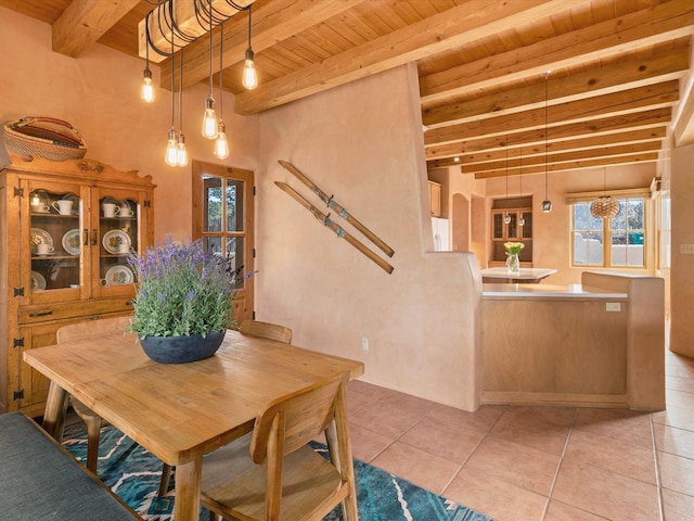 tiled dining space featuring beam ceiling and wood ceiling