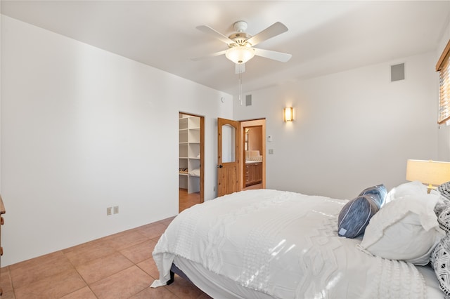 bedroom with tile patterned floors, a spacious closet, a ceiling fan, and visible vents