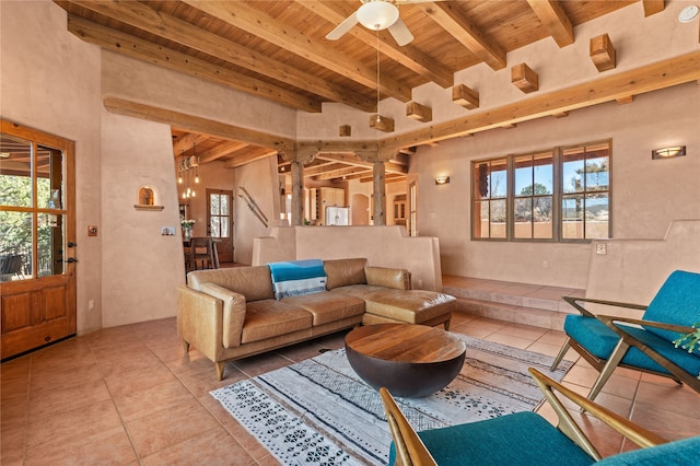 tiled living room featuring ceiling fan, beam ceiling, and wooden ceiling