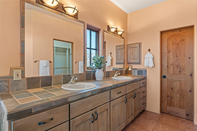 bathroom featuring a closet, tile patterned floors, double vanity, and a sink