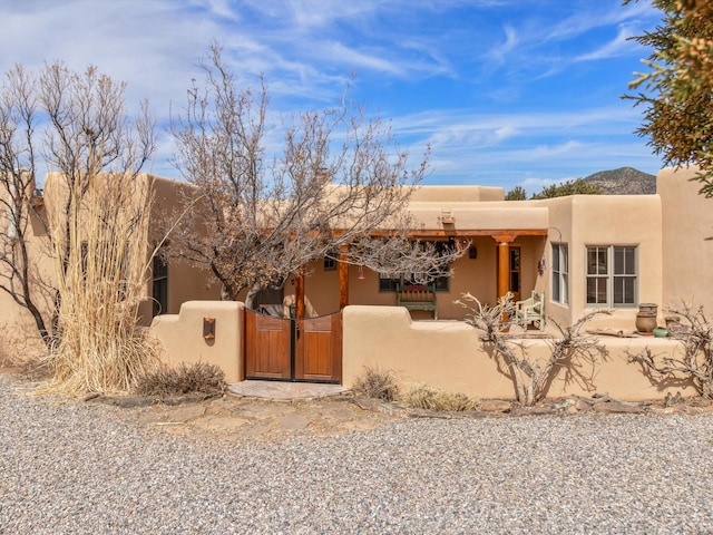 southwest-style home with a gate and a fenced front yard