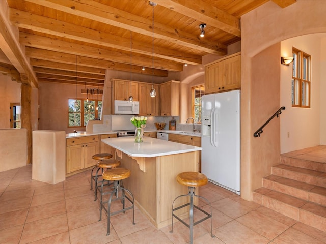 kitchen with light tile patterned floors, plenty of natural light, white appliances, and a sink