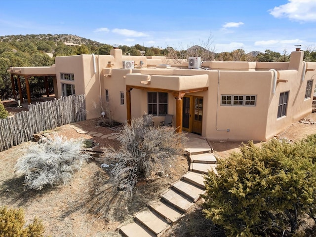 back of property with fence and stucco siding