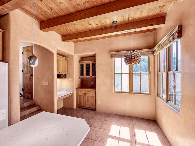 interior space with wood ceiling, light countertops, beam ceiling, light tile patterned floors, and hanging light fixtures