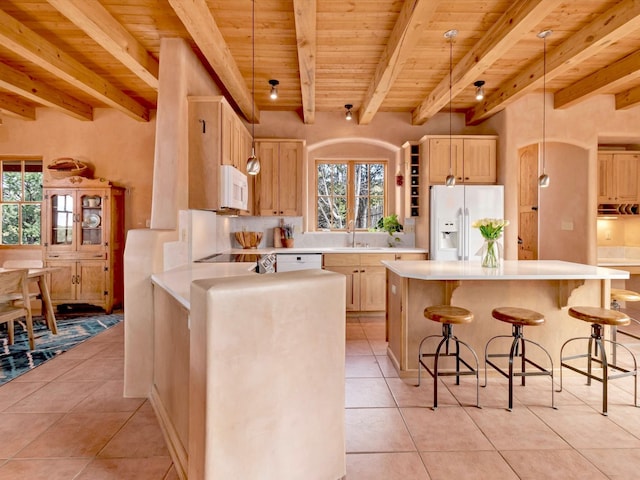 kitchen with white appliances, wood ceiling, light brown cabinetry, and light countertops