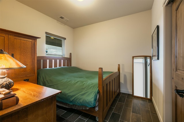 bedroom with baseboards, visible vents, and wood tiled floor